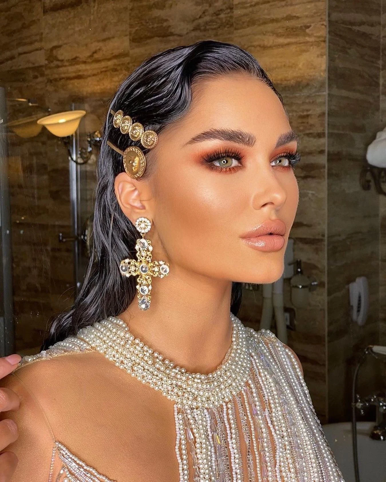 Warm copper eye makeup, defined lashes and a softly glossy nude lip